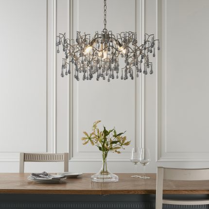 The Remi Silver Chandelier installed above a dining room table, with glass teardrops, 4 lights and a width of 75cm.