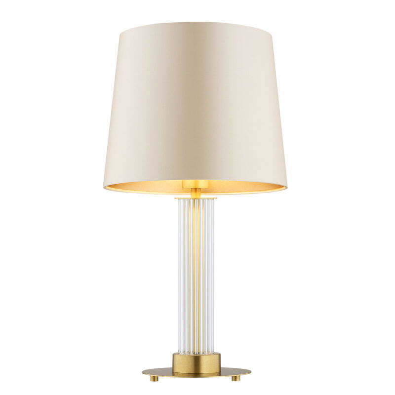 Beige fabric lamp shade and ribbed clear glass table lamp with the light bulb on.