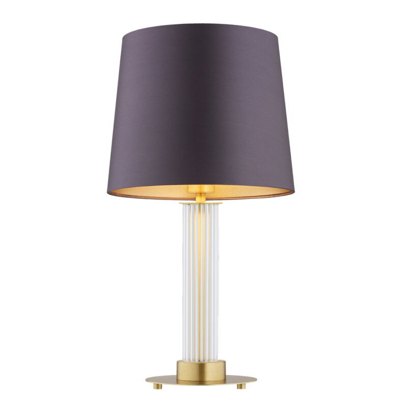 Full view with light bulb on of a glass table lamp with purple fabric shade.