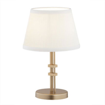 Old gold Arani table lamp with cream fabric shade and circular base with decorative clamps.