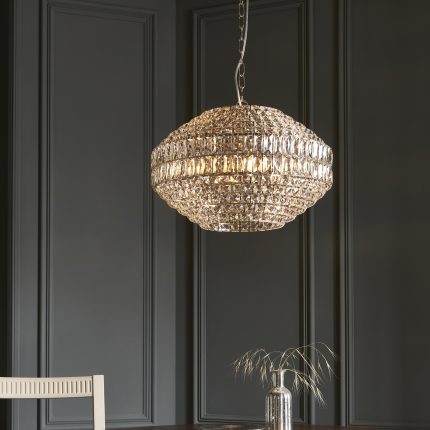 Zoomed in view of the bottom half of the Cora Chandelier with crystal glass and polished nickel finish, hanging in a room.
