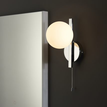 Close up right angle view of the Ando IP44 Wall Light with chrome pull cord switch and opal glass globe.