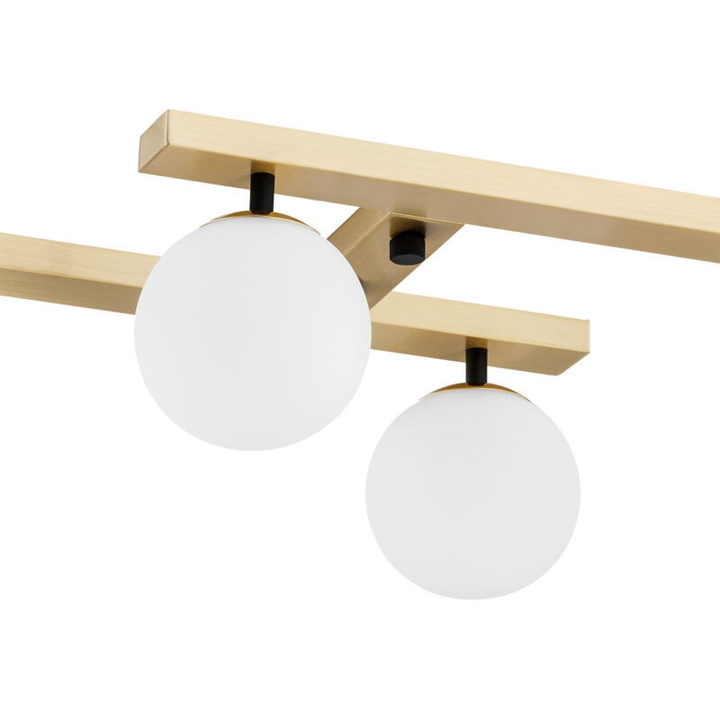 Close-up view of two Emont fixtures with opal glass shades and brass trim on intersecting tracks.