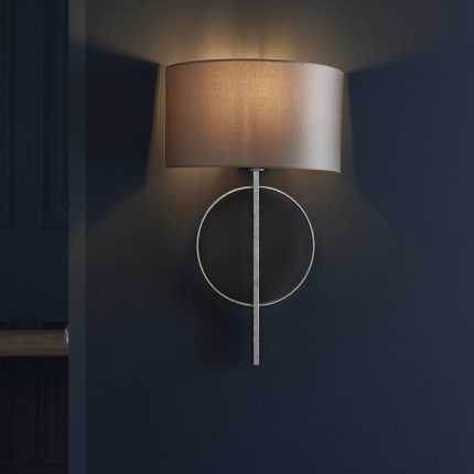 Close up view of Oratio Wall Light with silver leaf ring and mink half drum shade, installed on a wall.