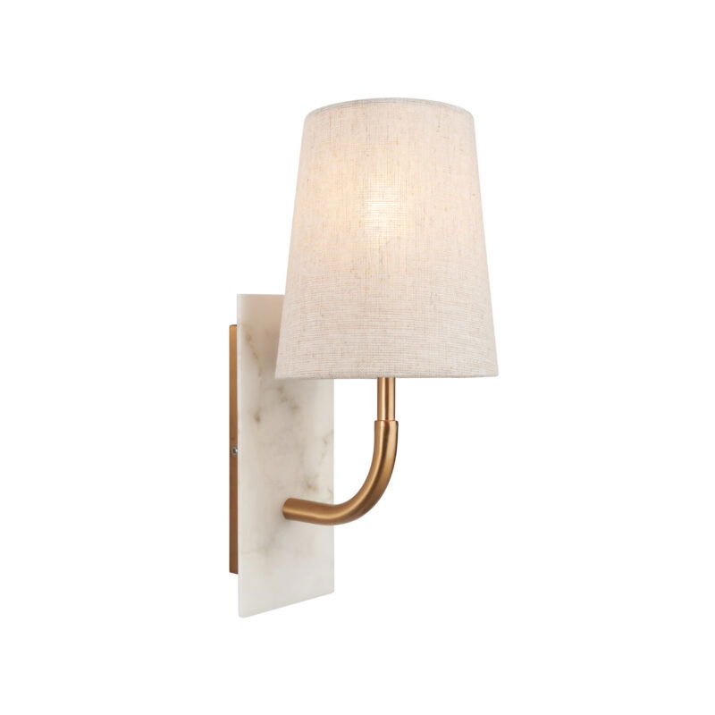 Wall lamp with brass curved arm, marble base and white tapered shade lit from within, viewed from left side.