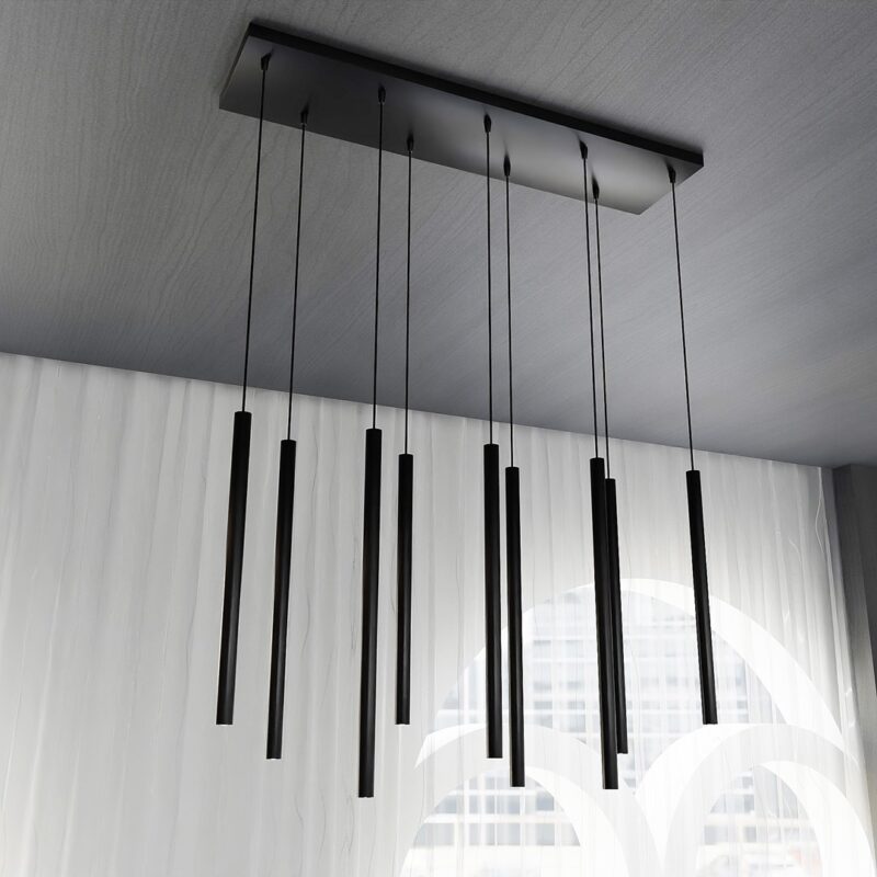 Side view of a black pendant light with 9 cylinder shaped tubes hanging down.