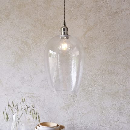 Pendant light with clear hammered glass shade and nickel hardware viewed at eye level, measures 25cm.