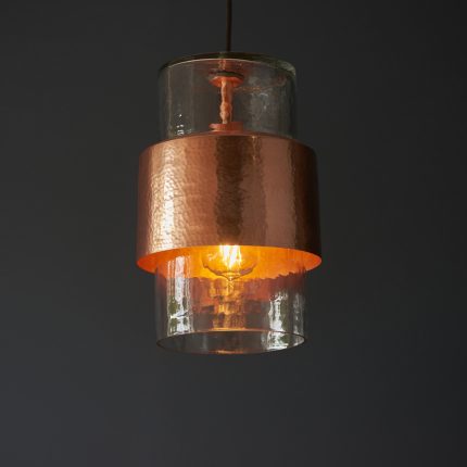 Close-up shot of Haruto pendant's glass shade meeting hammered copper mounting steel.