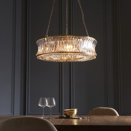 Close up of the Ares Flat Chandelier with 6 lamps in brass and clear crystal, 61cm, hanging above a dining table.