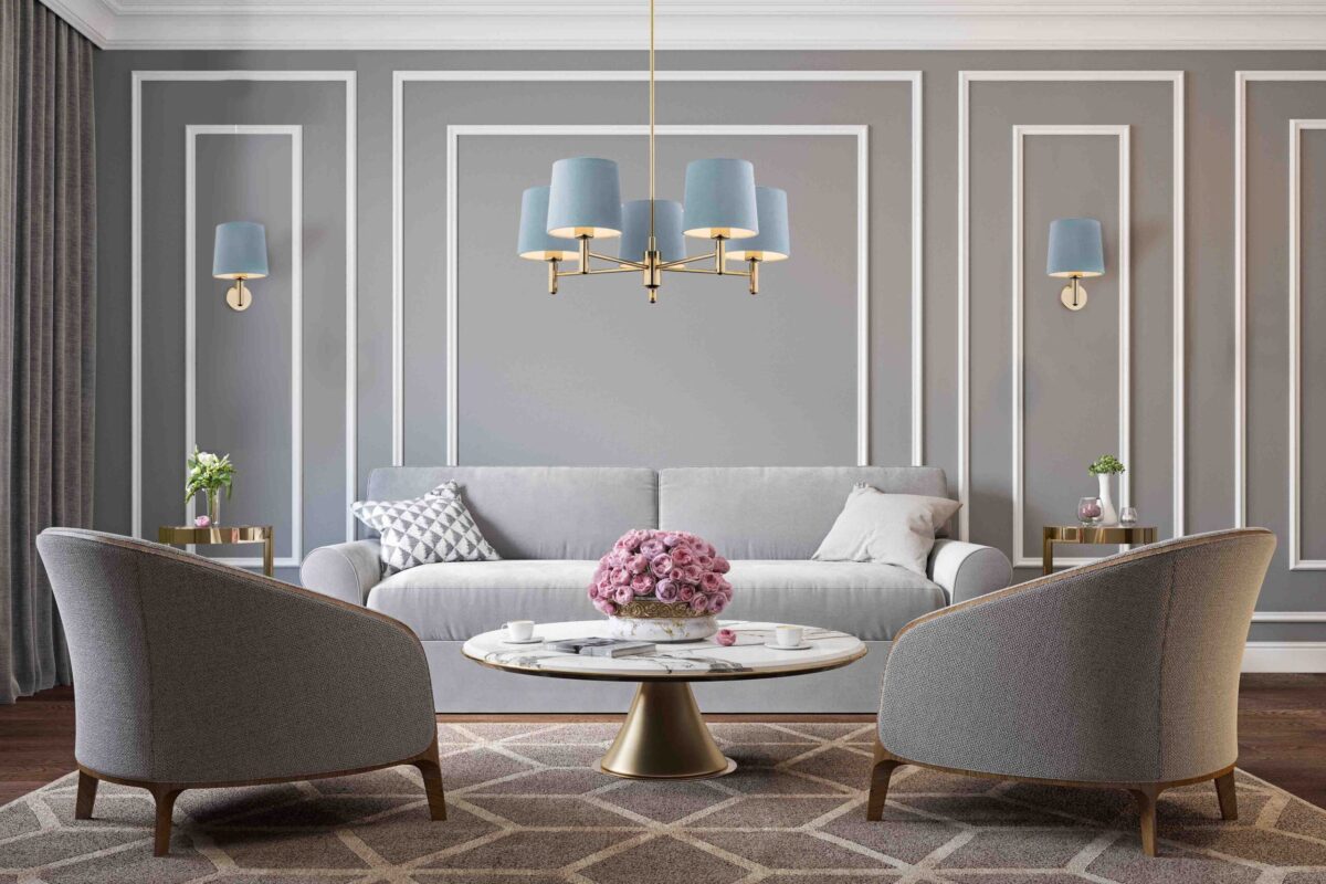 Five-arm brass chandelier with sky blue shades hanging in a living room above a seating area.