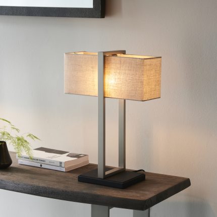Antio table lamp in satin nickel finish with a rectangle lampshade, placed on a wooden side table.