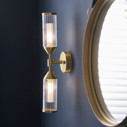 Side view of the Mauris Double Wall Light, Brass, Ribbed Glass, installed next to a mirror.