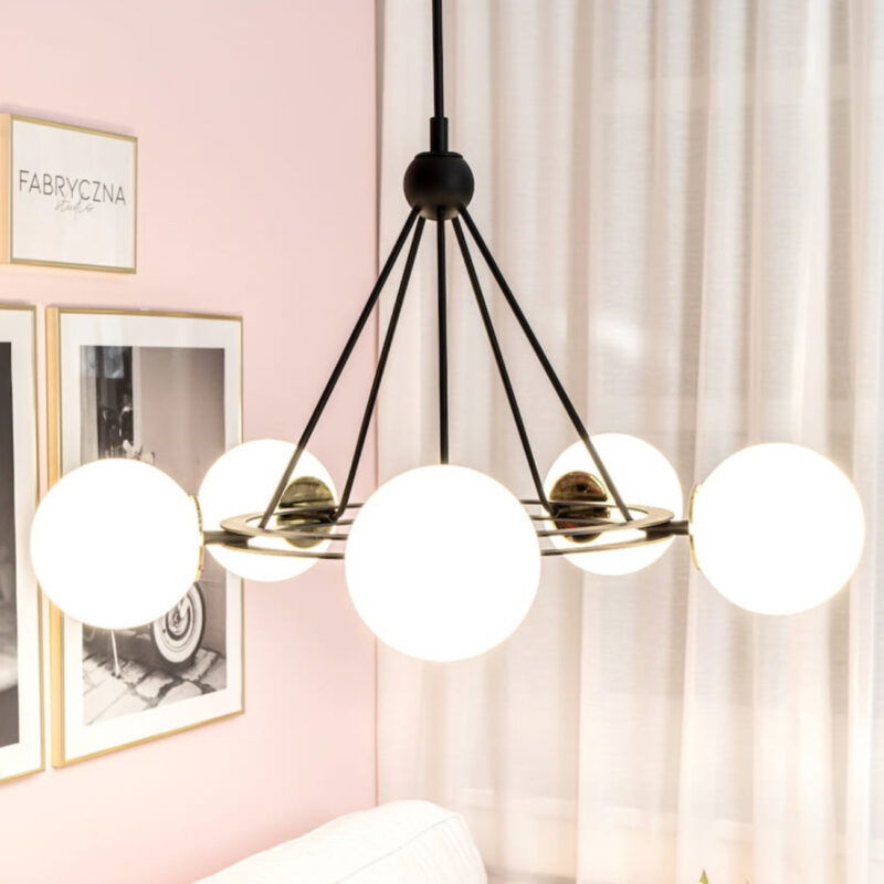 Side view of Malfia 5-light chandelier with black frame, brass accents and opal globes.