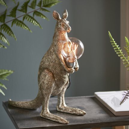 Side view at eye level of Twig The Kangaroo table lamp in vintage silver on a desk.